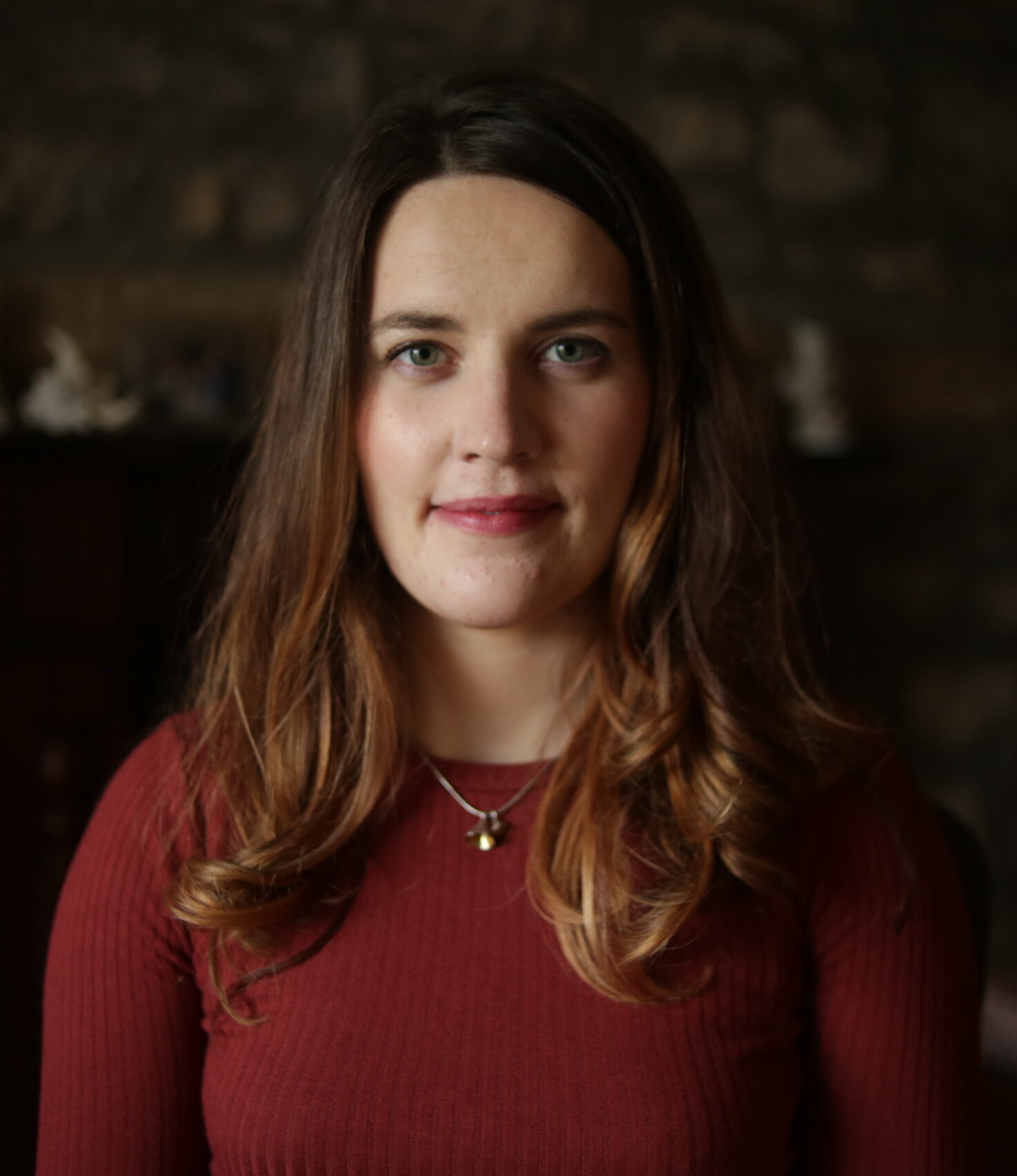 aideen Caucasian woman with brown hair wearing dark red shirt in dark room